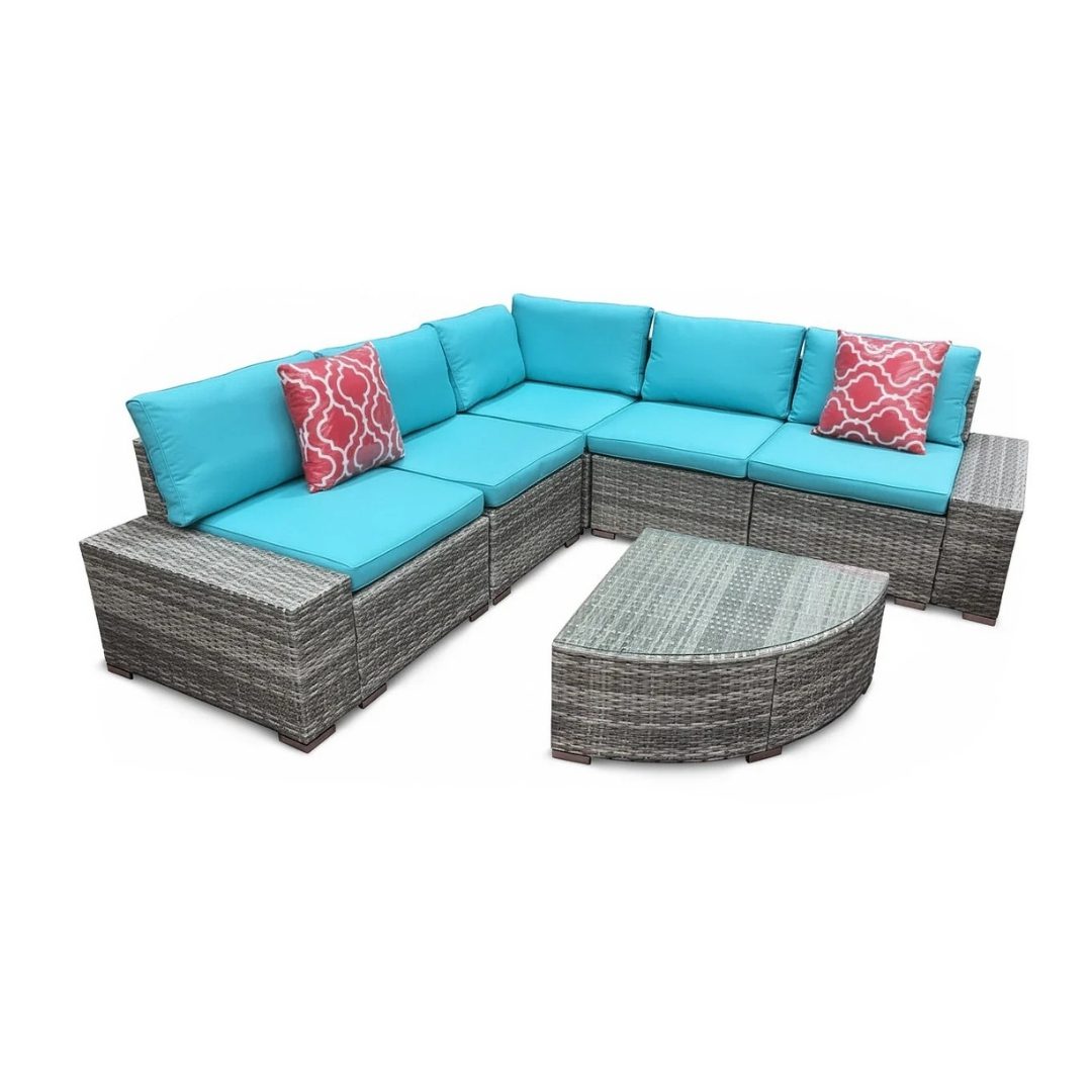 Grey rattan garden furniture set with blue cushions on patio